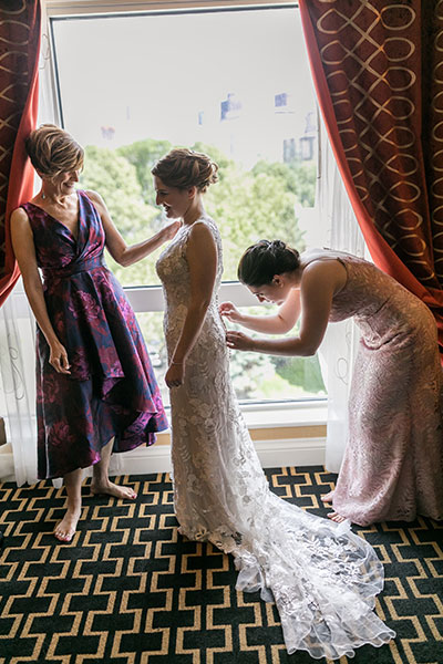 Bride getting help in wedding dress