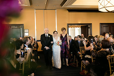 Bride walking down aisle with family