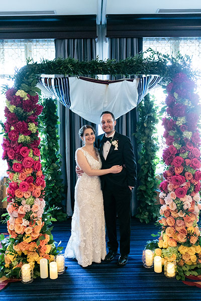 Wedding couple under floral arch