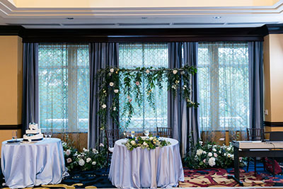 Wedding reception table with floral pieces in background