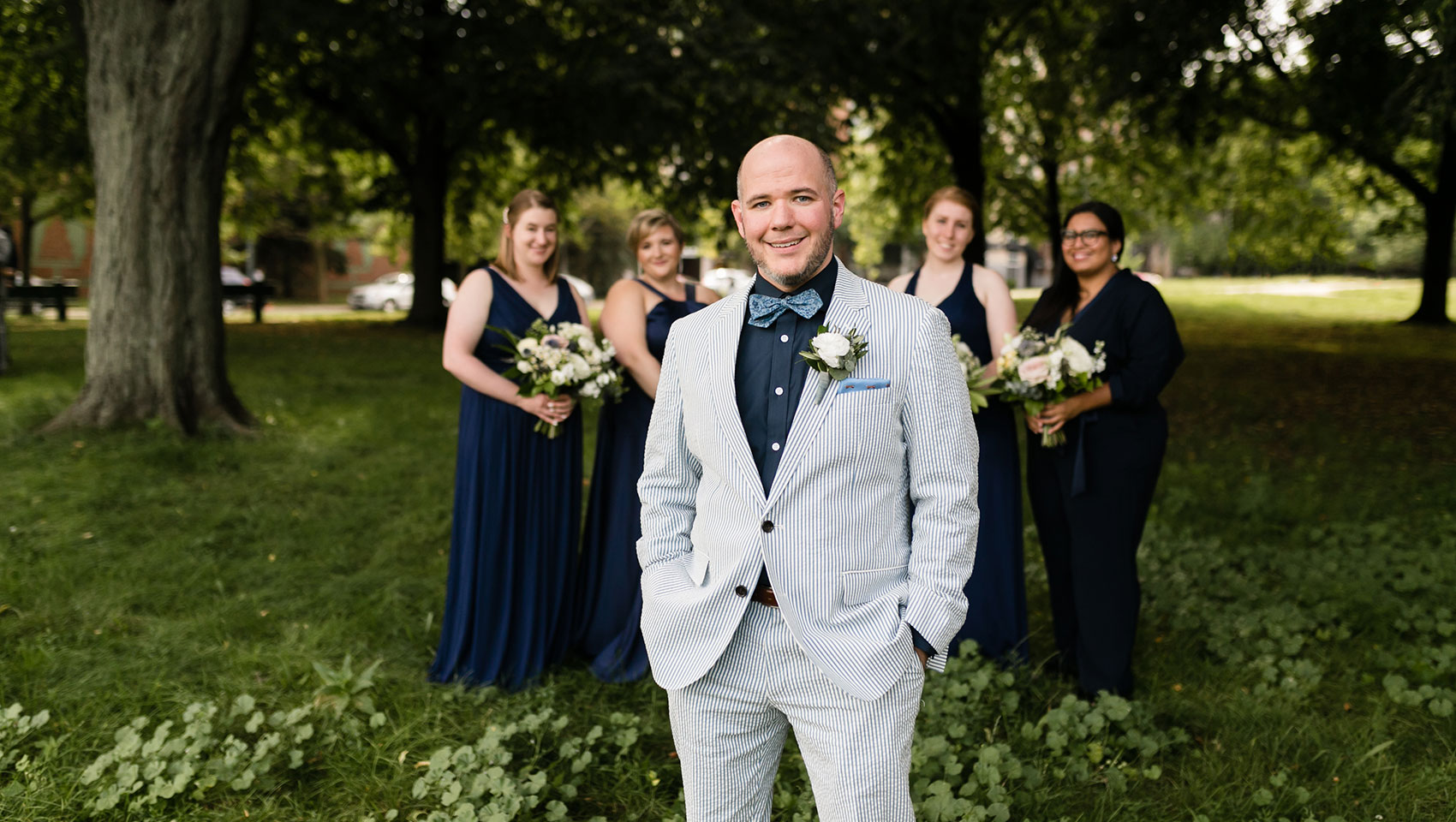 Groom in front of bridesmaids