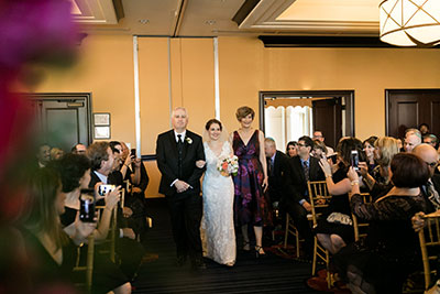 Bride walking down aisle with family