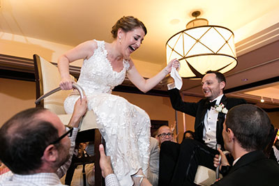 Bride being lifted up on chair
