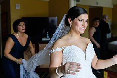 Bride having her veil adjusted by family member