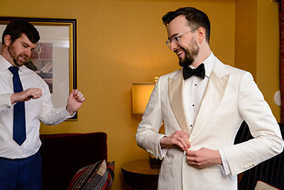 Groom buttoning jacket and smiling