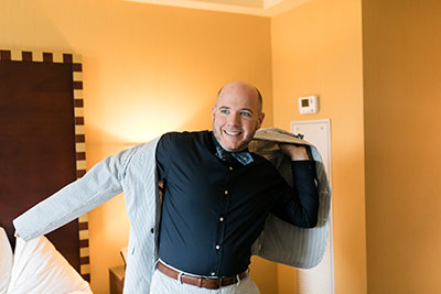 Groom putting on seersucker jacket