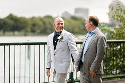 Grooms holding hands in wedding attire